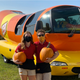 Hotdoggers Mustard Mags and Zach n Cheese pose with the Wienermobile